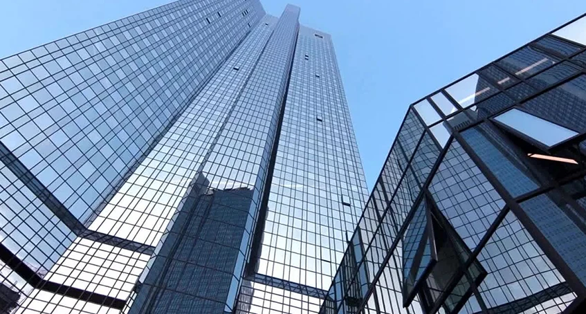 Modern Skyscrapers With Extensive Commercial Glass and Doors Reflecting Blue Sky