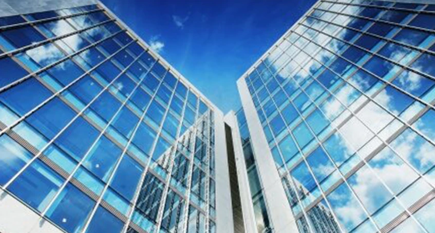 Modern Glass Building with Reflective Windows Under a Blue Sky