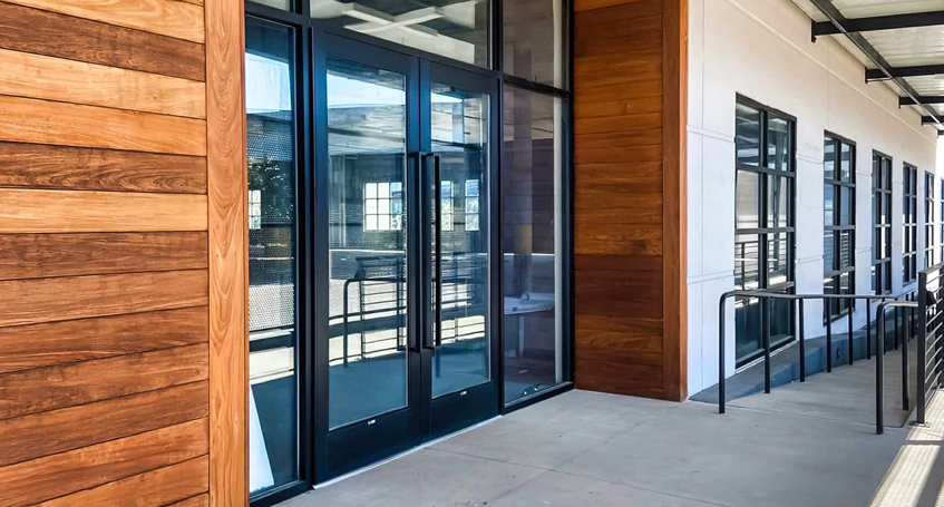 Modern Commercial Glass Doors with Wooden Siding and Railings